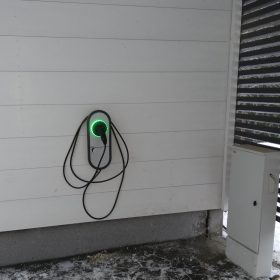 Sähköauton latausasema autotallissa.