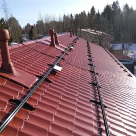 Kiinteistön katto, jossa asennettuna aurinkosähköpaneelien kiskot.